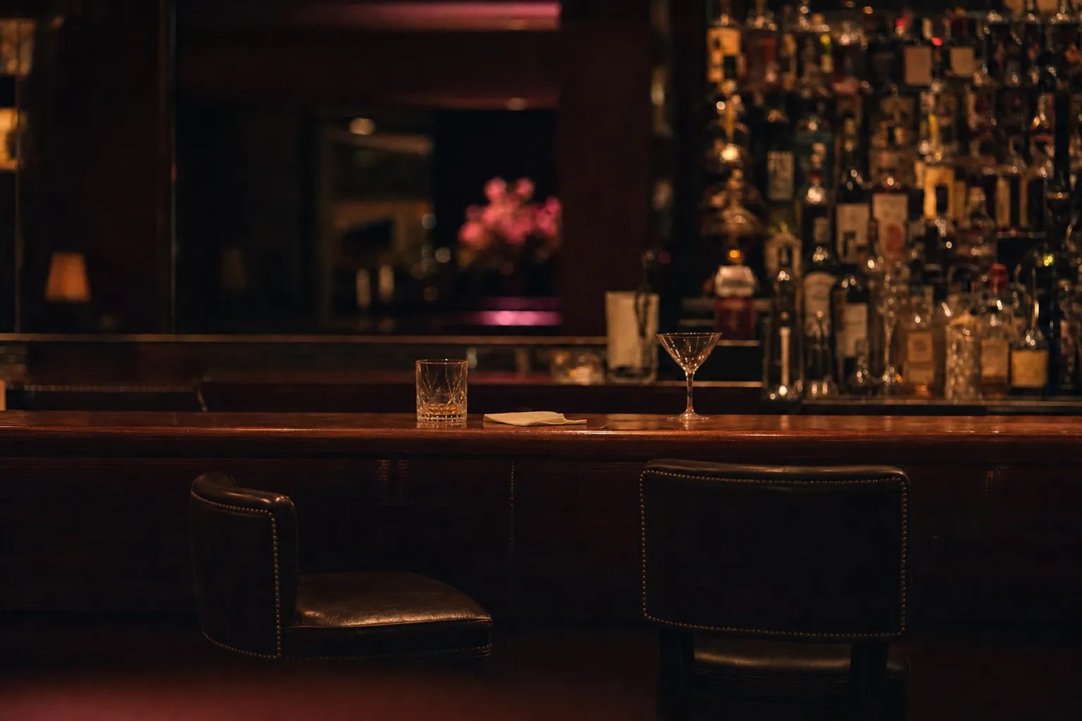 The bar at closing time, empty, with one stool turned out and two finished glasses left side by side
